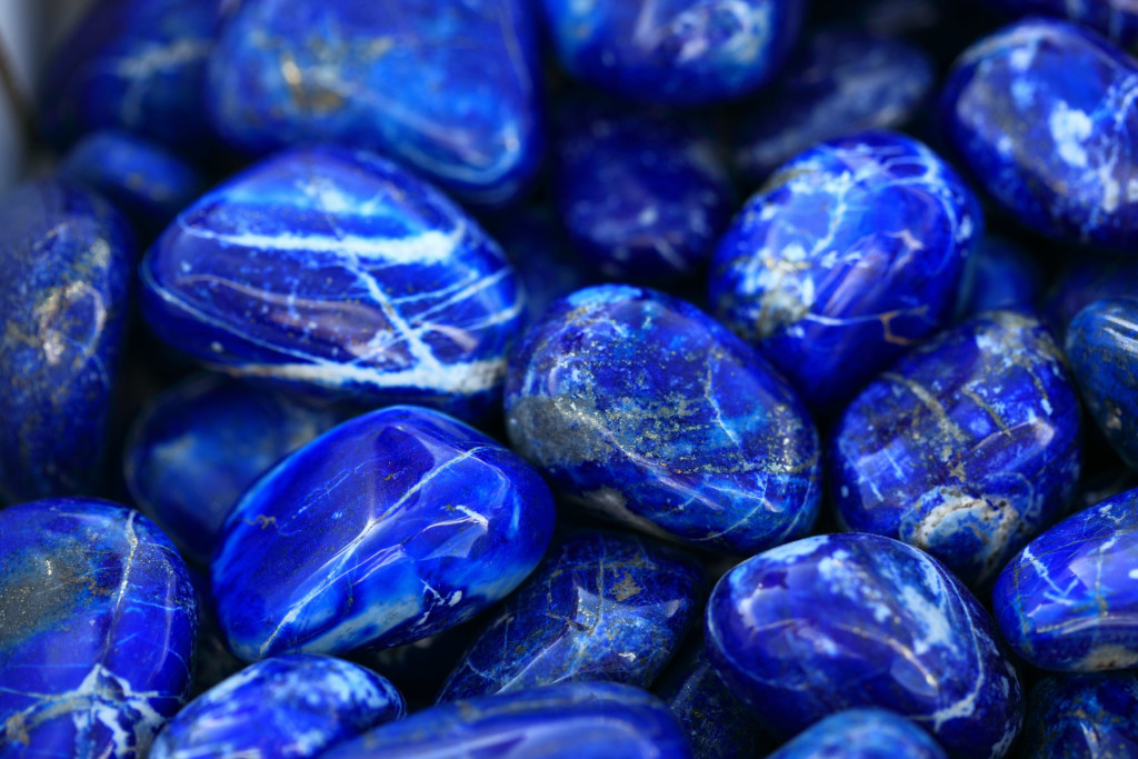 A macro shot of the center of a box full of polished blue stones, lapis lazuli.  Seen at the TEP venue of the Tucson Rock and Gem Show, 2012 in Tucson, Arizona.